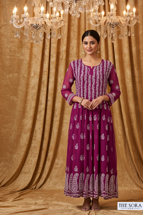 Woman wearing a purple dress with white patterns against a gold curtain background