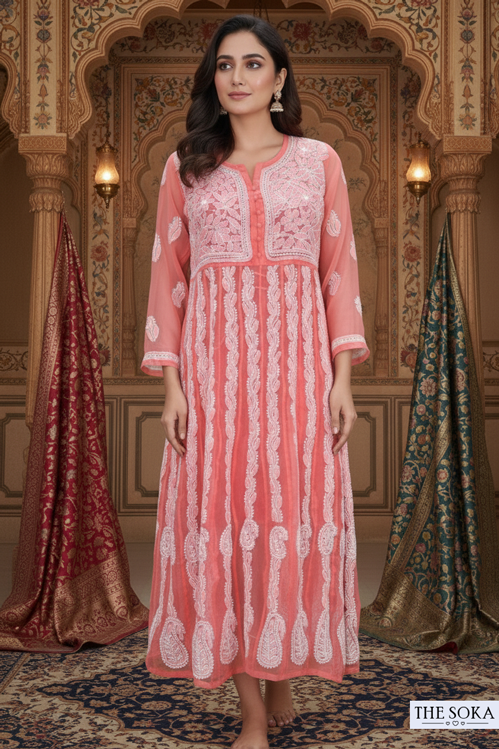 Woman wearing a pink and white embroidered dress in an ornate room.