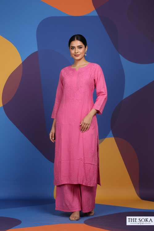 Woman in a pink traditional outfit standing against a colorful abstract background