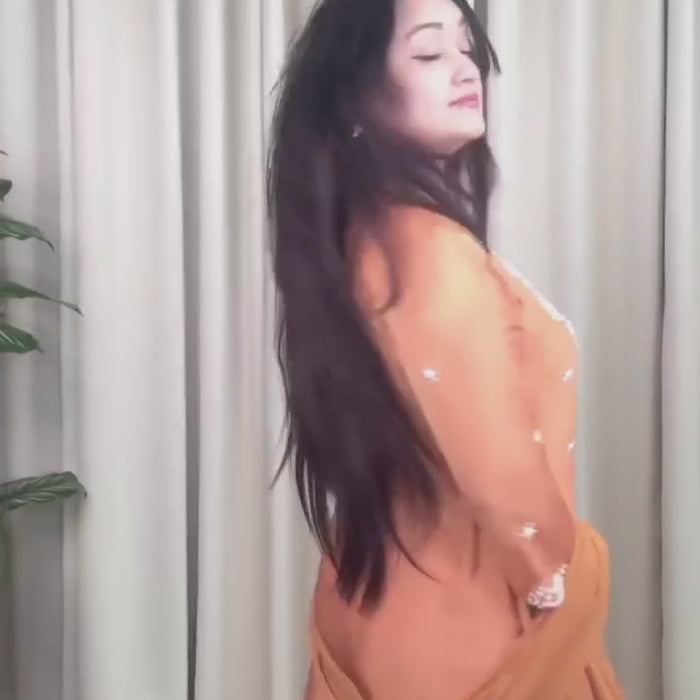 Woman wearing an rust orange sharara set 